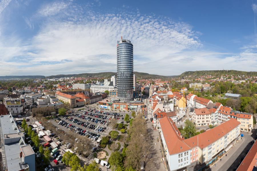 Ein großer Parkplatz mit einem modernen Turm dahinter