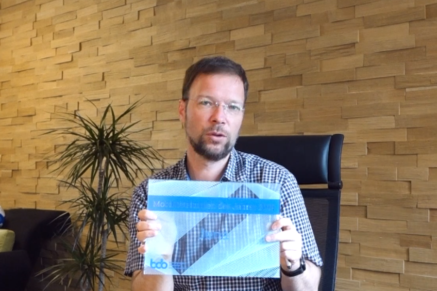 Ein Mann hält ein Schild in die Kamera
