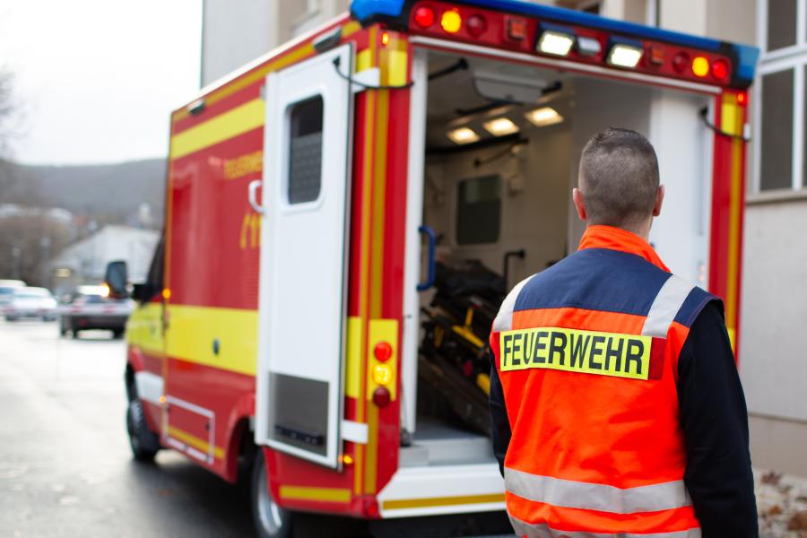 Ein Rettungswagen der Feuerwehr, ein Helfer im Vordergrund