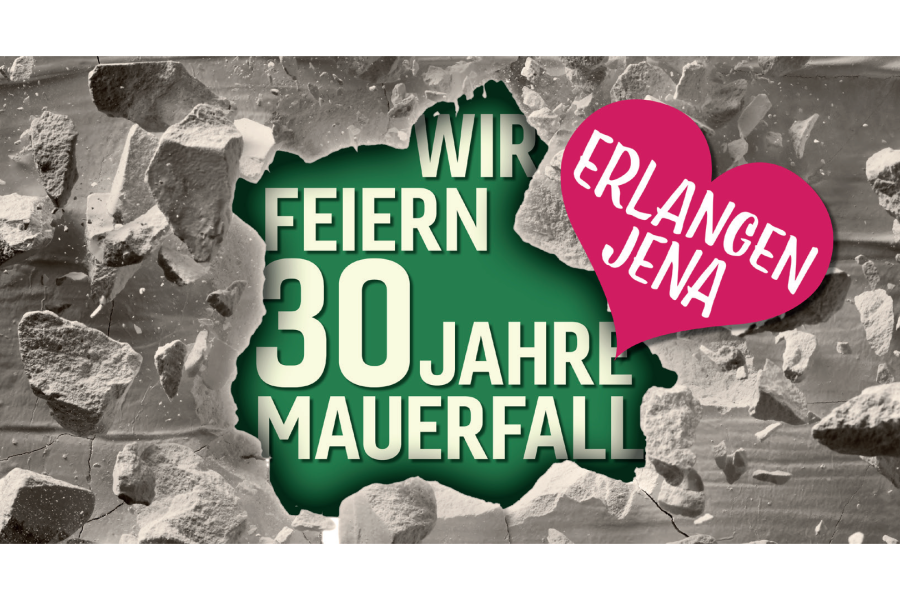 Eine Grafik zeigt eine Mauer mit einem Loch. In dem Loch steht "Wir feiern 30 Jahre Mauerfall". Auf der Mauer ist ein Herz mit dem Schirftzug "Erlangen Jena" 