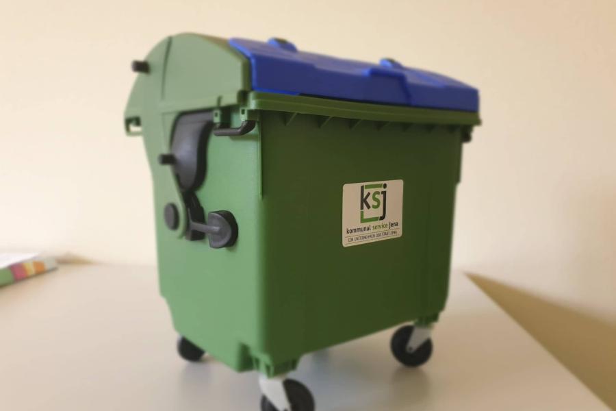Ein grüner Miniatur-Müllcontainer von KSJ