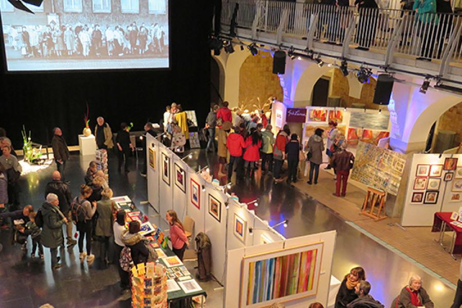 Ein großer Raum mit Kunst und vielen Menschen