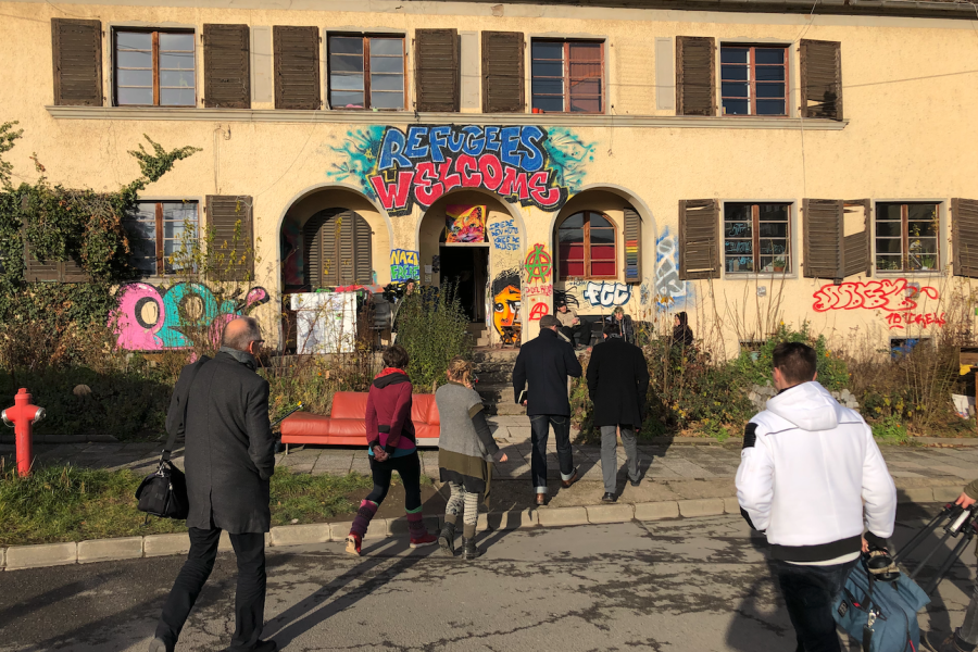Ein Haus mit Menschen im Vordergrund