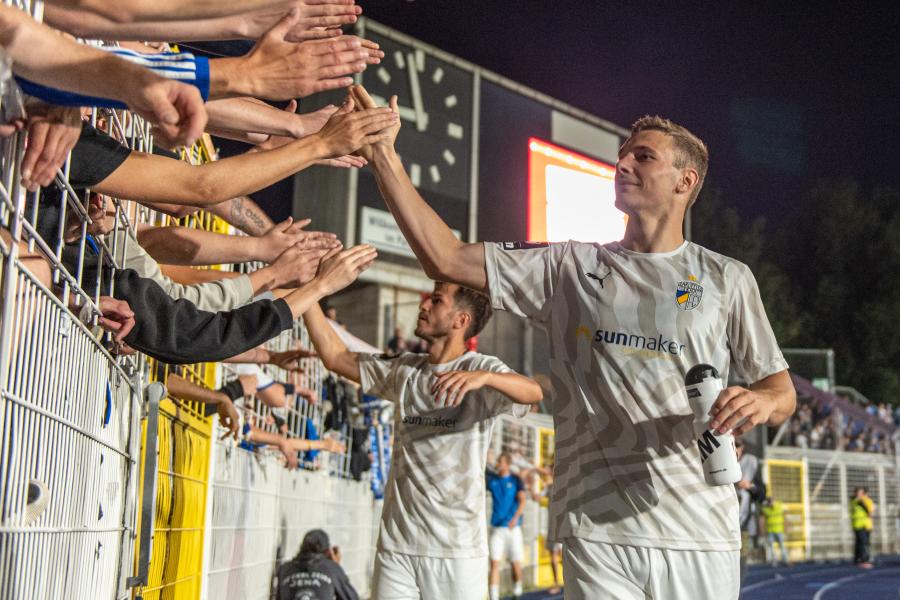 Fußballer klatschen Hände der Fans ab