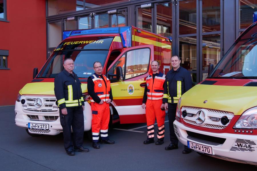 Vier Männer an zwei Fahrzeugen 