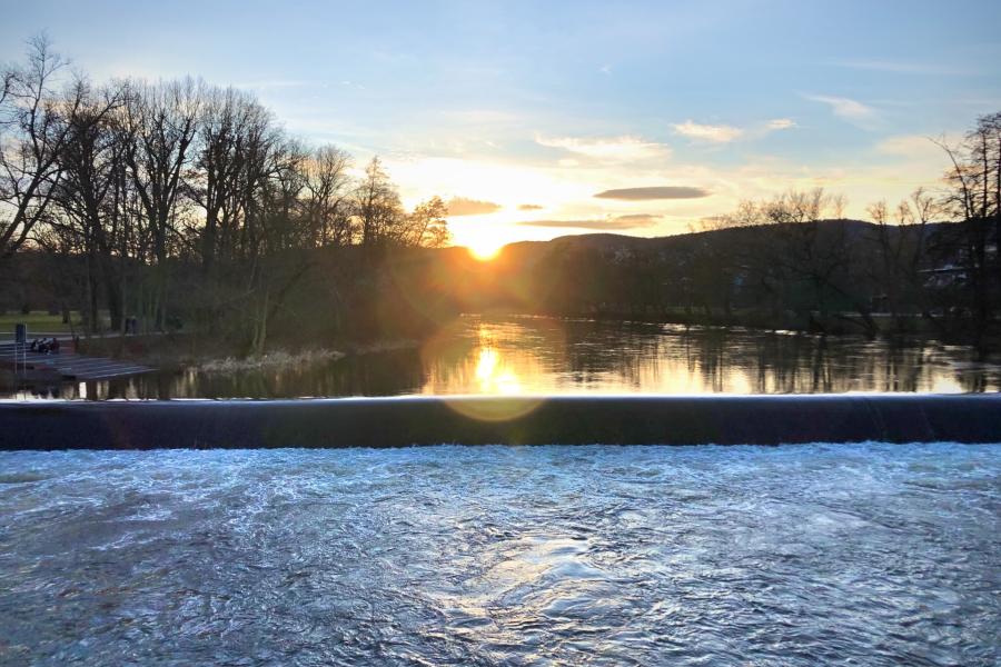 Ein Wasserwehr mit untergehender Sonne