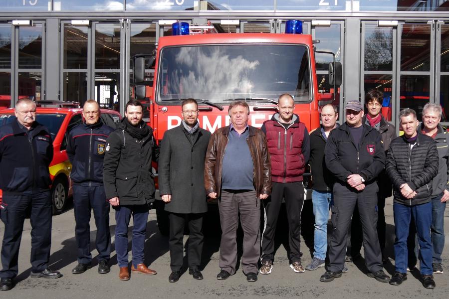 Eine Gruppe von Menschen vor einem Feuerwehrwagen
