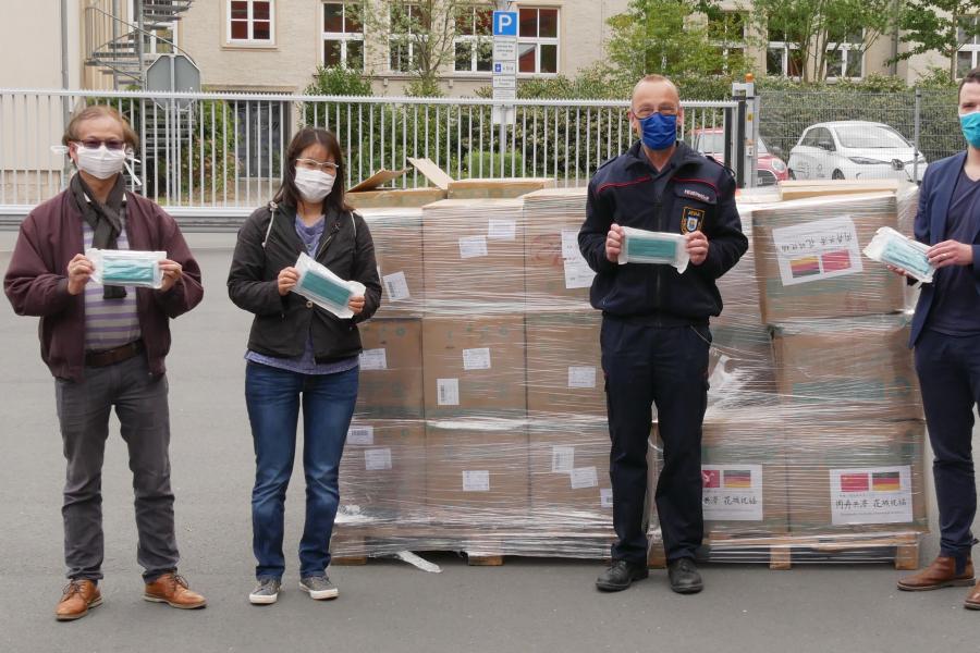 Vier Menschen vor einem großen Paket
