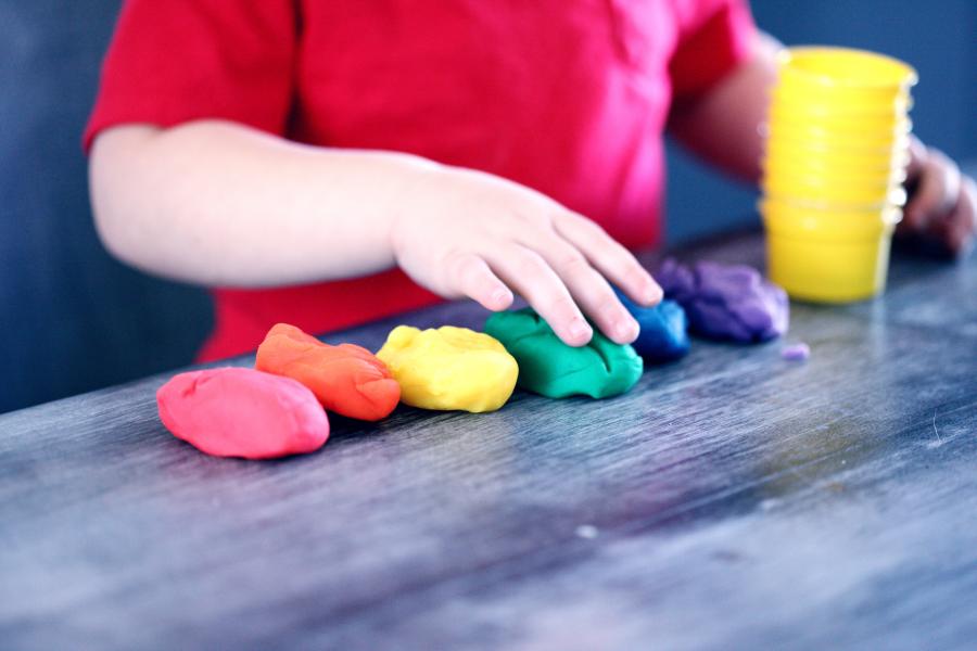 Kinderhand formt bunte Knete