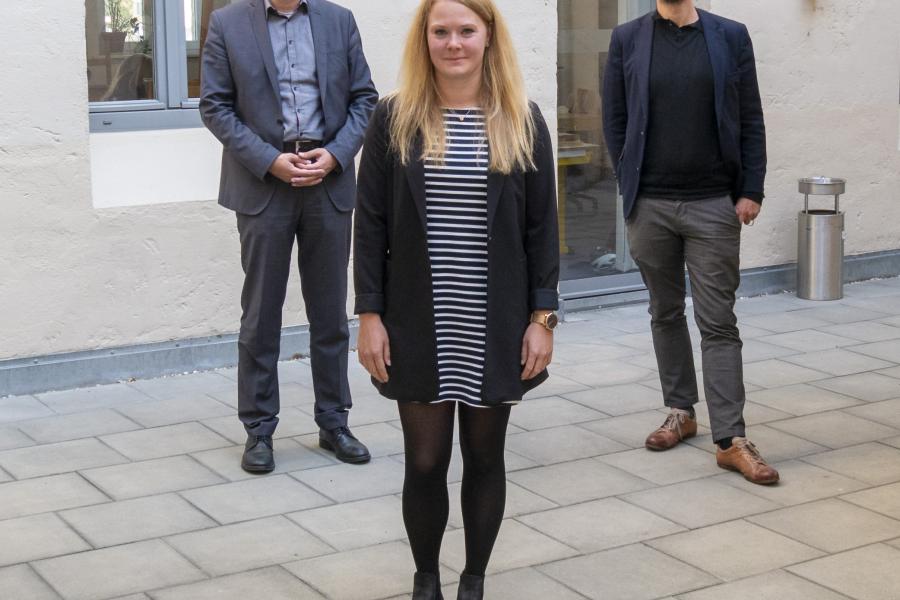 Drei Personen schauen in die Kamera