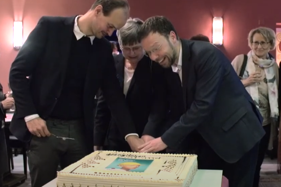 Drei Menschen schneiden eine Torte an