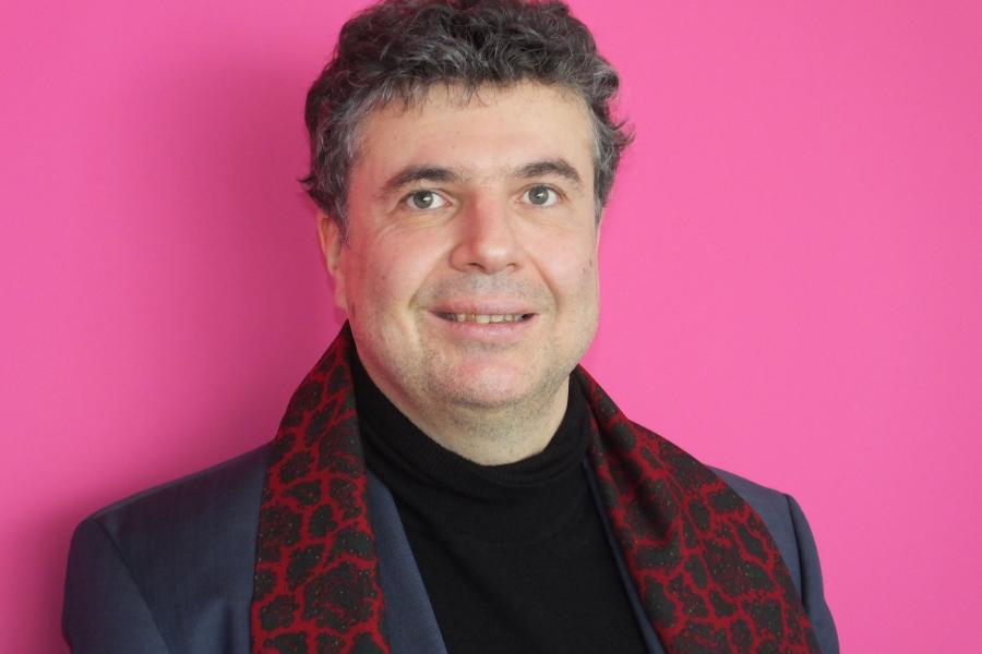 Ein Mann mit Künstlerschal schaut in die Kamera