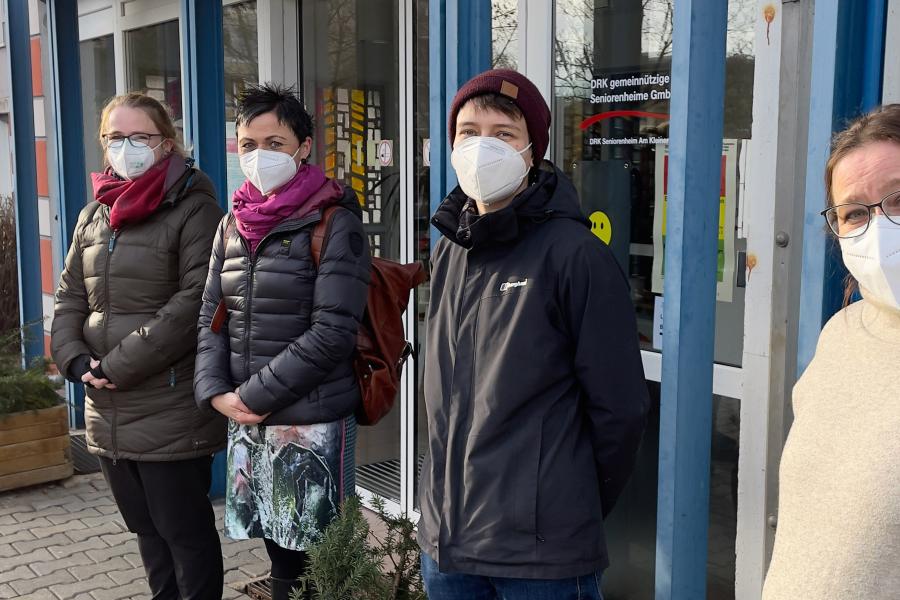 Vier Frauen mit Schutzmaske vor einem Altenheim
