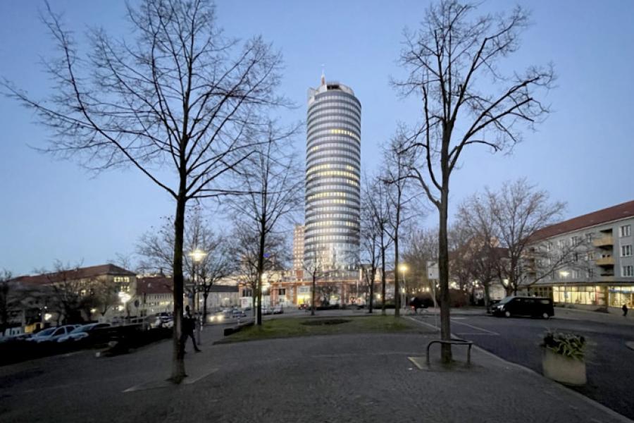 Der Jentower im Vordergrund zwei Bäume ohne Blätter