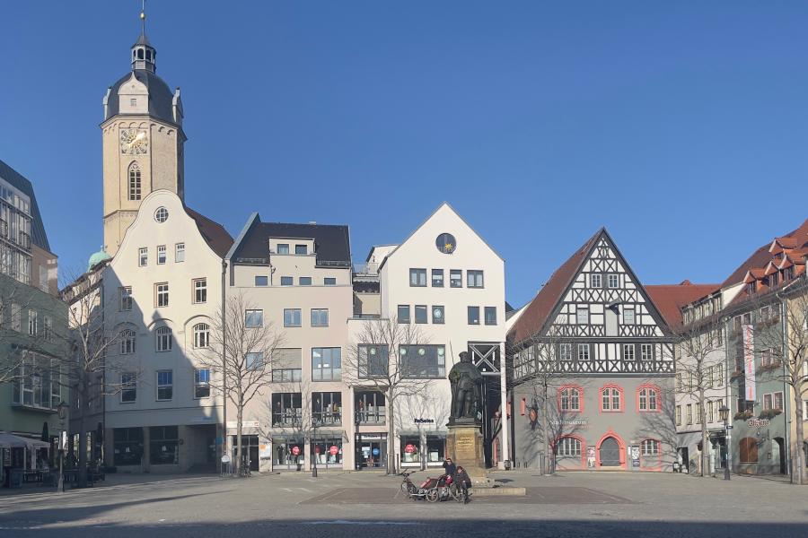 Eine Platzmit Denkmal, im Hintergrund Häuser