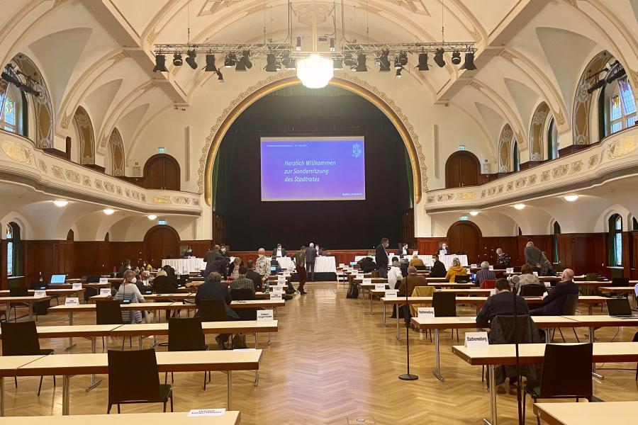 Ein großer Saal mit Tischen, an denen Menschen sitzen