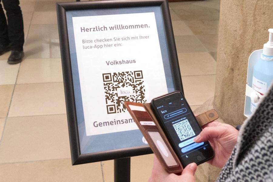 Eine Person hält ein Handy an einen Barcode