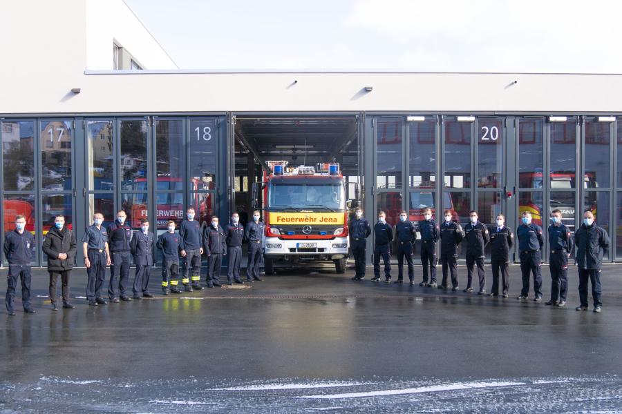 Viele Männer in Uniform vor einem Feuerwehrwagen