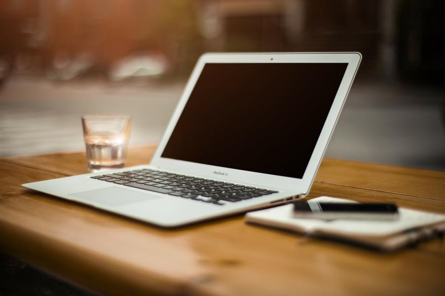 Tisch mit Laptop, Glas und Block