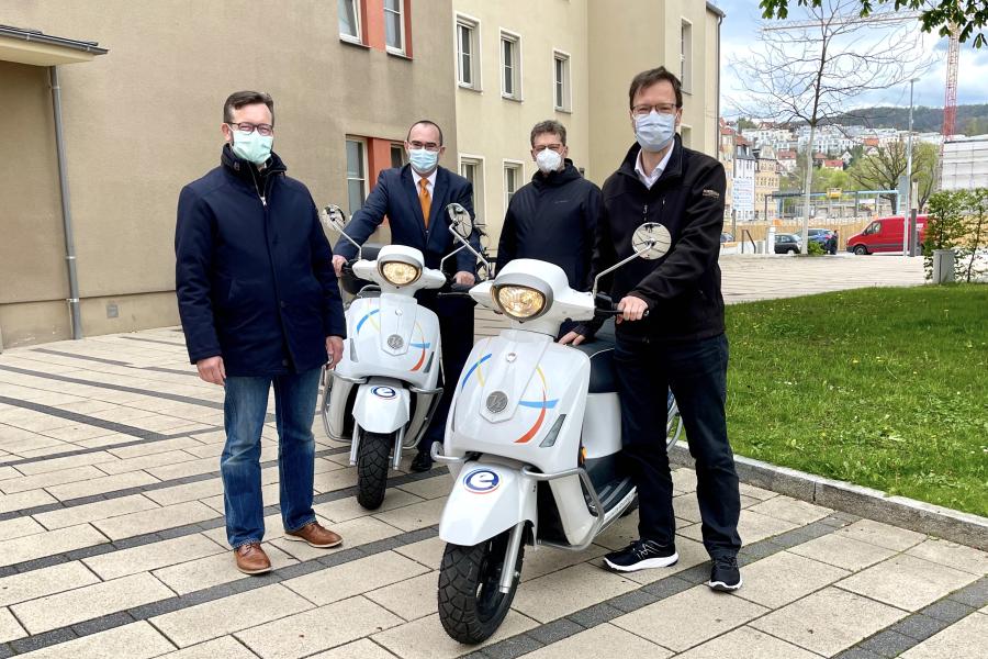 Vier Männer mit zwei Motorrollern