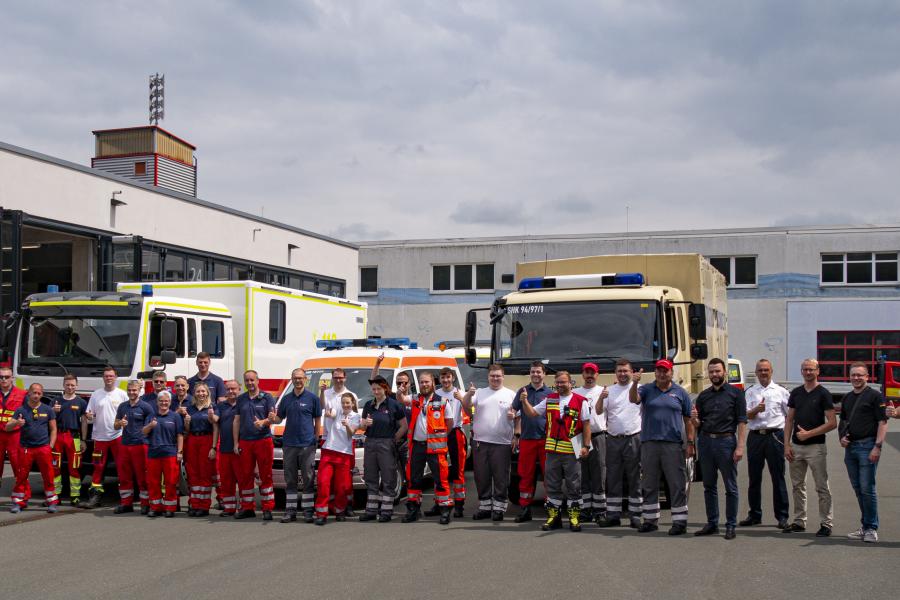 Viele Menschen vor Einsatzfahrzeugen des Katastrophenschutzes