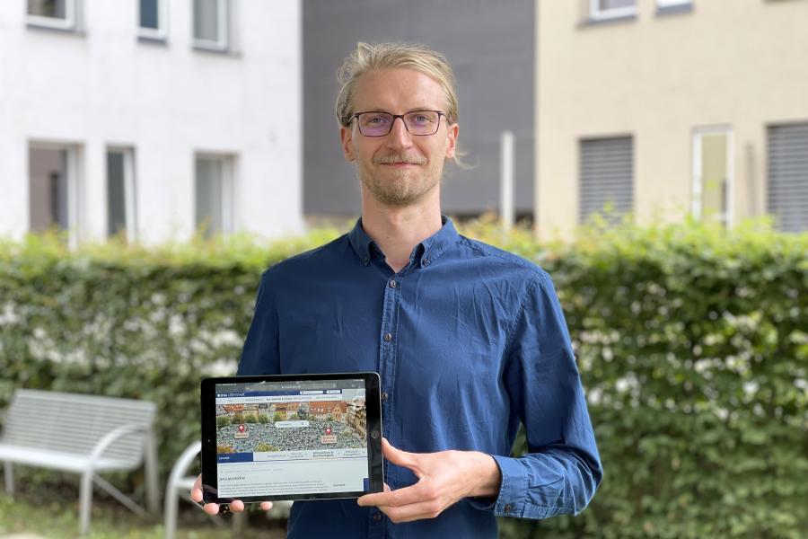 Ein Mann hält ein iPad in die Kamera 