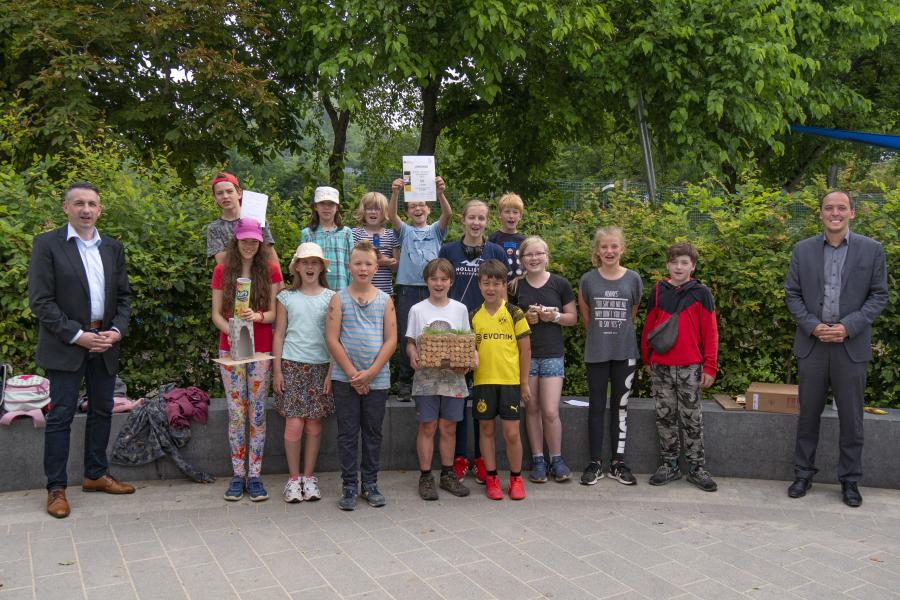 Viele Kinder und zwei Männer lachen in die Kamera