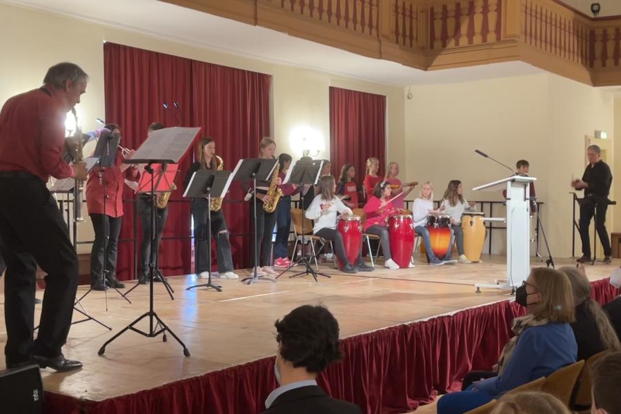 Viele musikspielende Menschen auf einer Bühne