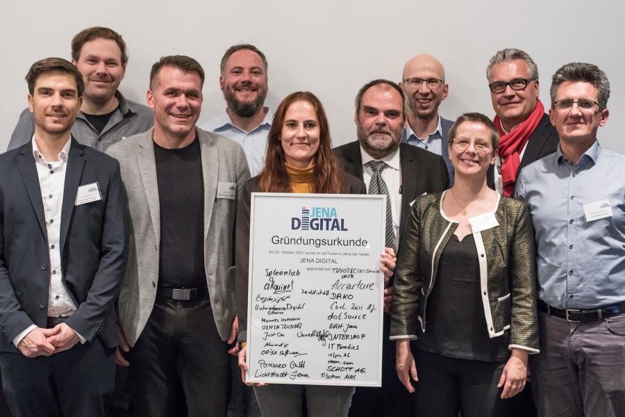 Mehrere Personen haben sich aufegstellt und halten ein großes Schild vor sich