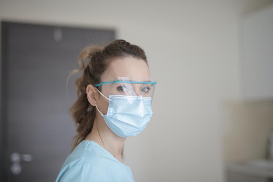 Eine Pflegekraft mit Maske und Visier 