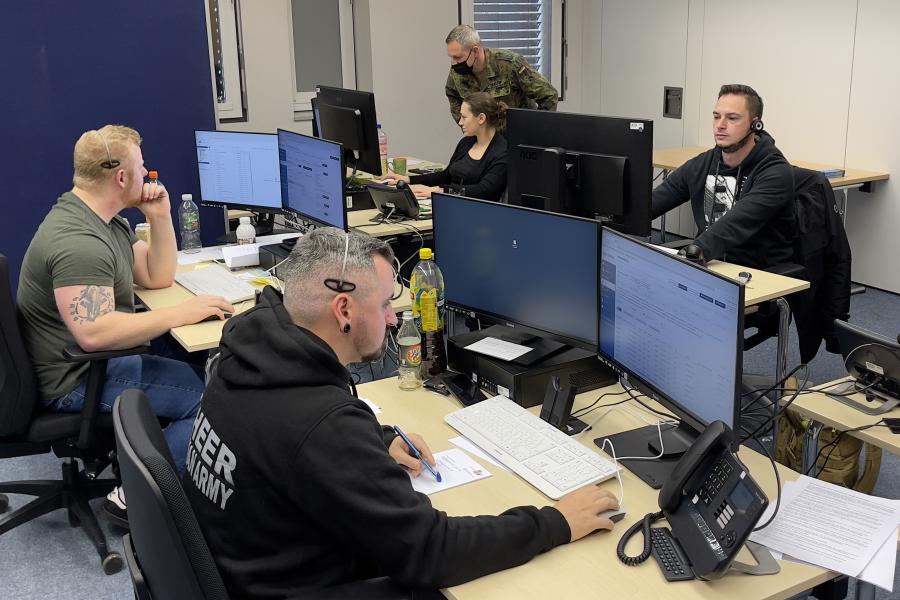 Vier Personen in einem Raum am Telefon