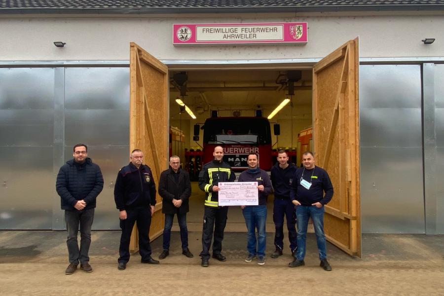Feuerwehrmänner halten einen Scheck 