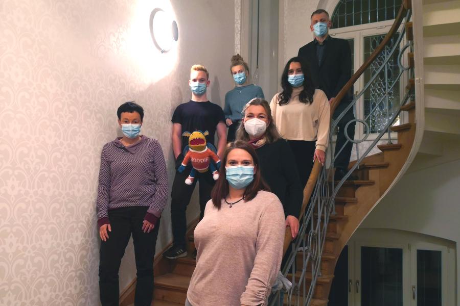 Viele Menschen auf ein Treppe, alle tragen Maske