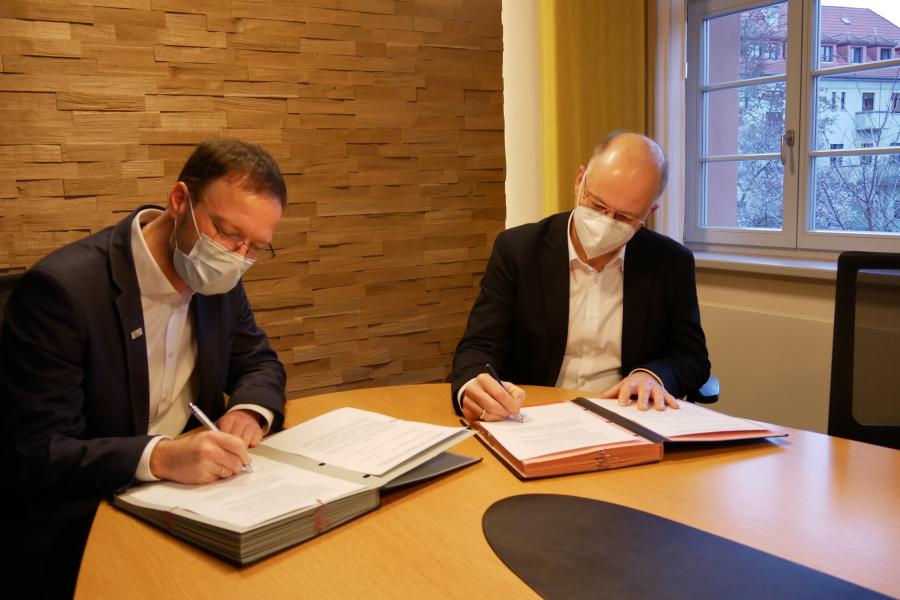 Dr. Thomas Nitzsche und Tobias Wolfrum unterzeichnen den Kooperationsvertrag zur Unterbringung von Geflüchteten.
