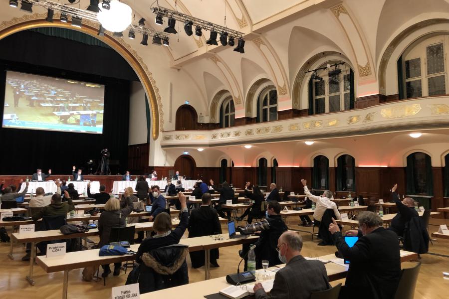 Ein großer Saal mit Menschen am Tisch