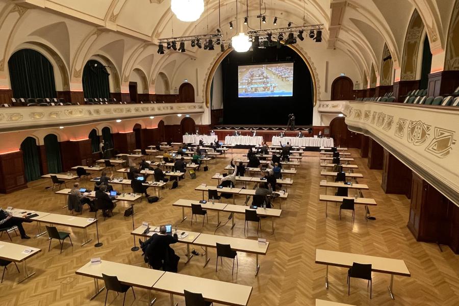 Ein großer Saal mit Menschen am Tisch