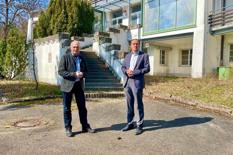 Zwei Menschen vor einer Villa