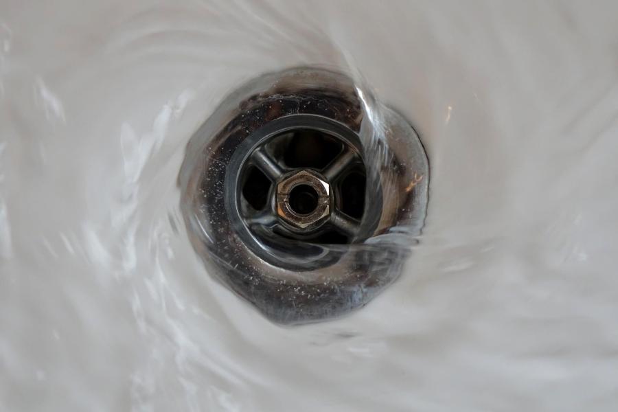 Wasser fließt durch einen Abfluss ab.