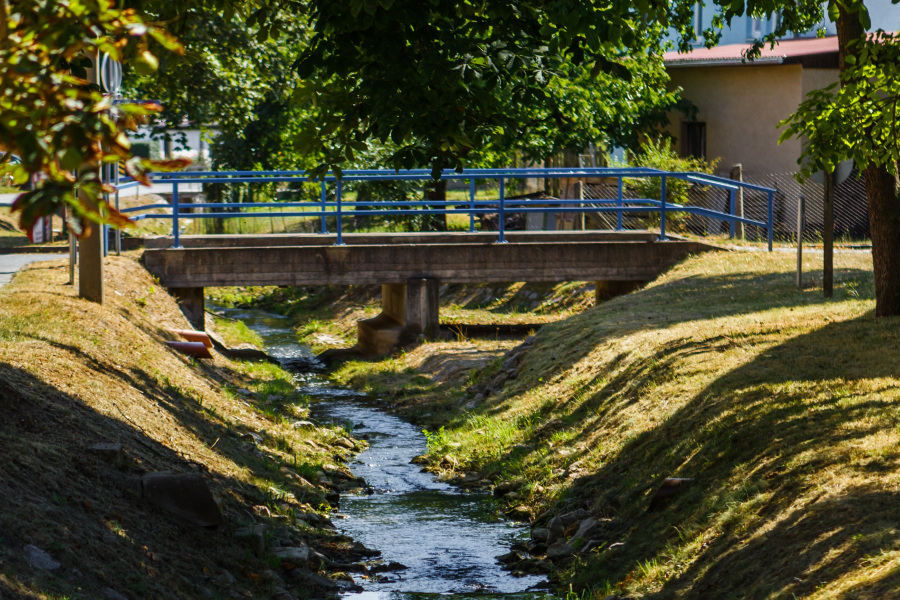Ein Bach fließt unter einer Brücke entlang.