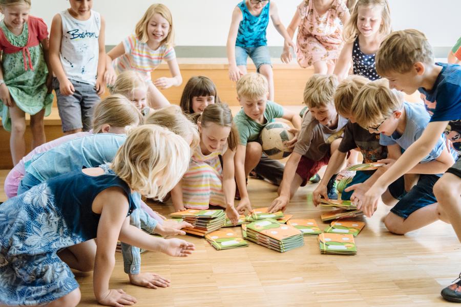 Grundschulkinder nehmen sich ausgelegt Möhrchenhefte