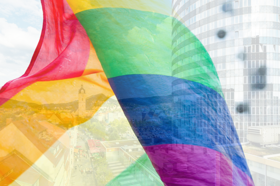 Blick auf die Innenstadt durch eine wehende Regenbogenfahne