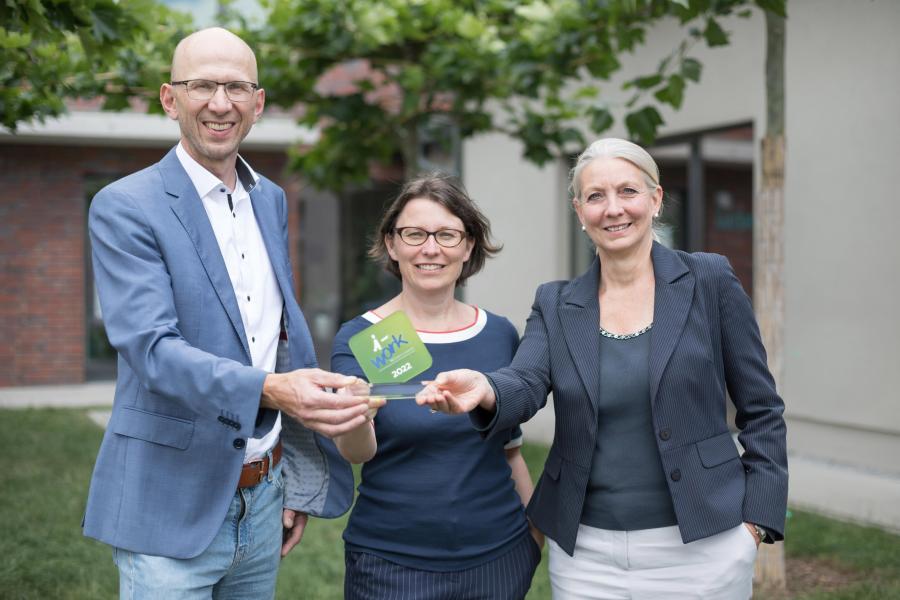 Ein Mann und zwei Frauen stehen nebeneinander.