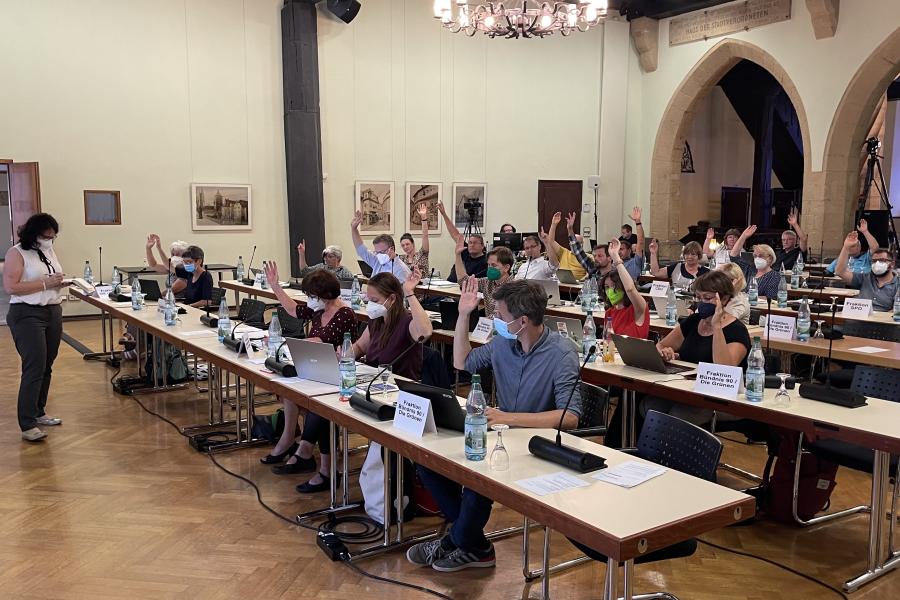 Abstimmung im Stadtrat. Jeder Stadtrat hat eine Hand gehoben.