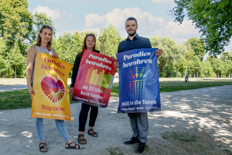 Drei Personen halten je ein Plakat in die Kamera