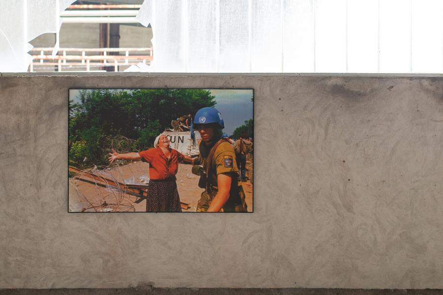 Fotografie in der Gedenkstätte Srebrenica mit einer bosnischen Frau und eines Blauhelm-Soldaten