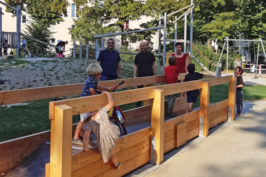 Erwachsene und Kinder an einer großen Wippe