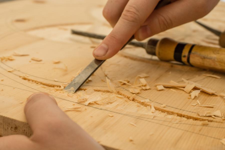 Mensch feilt an Holzplatte