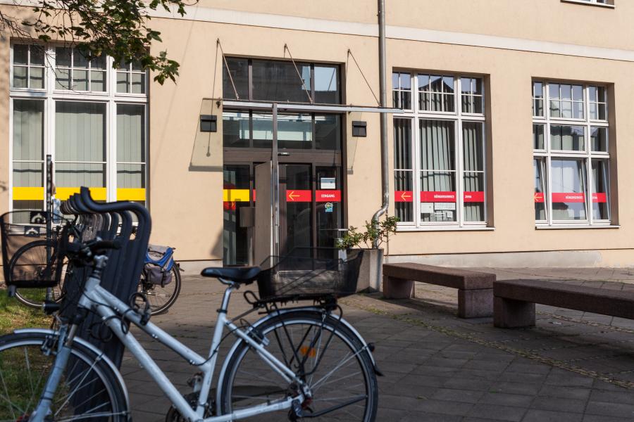 Ein Hauseingang, im Vordergrund Fahrräder