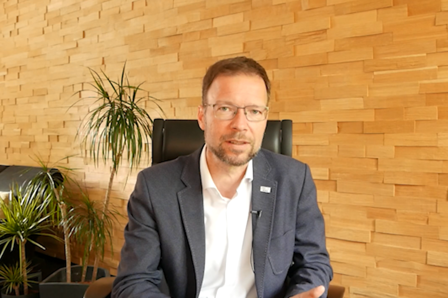 Der OB sitzt an einem Tisch und spricht in die Videokamera