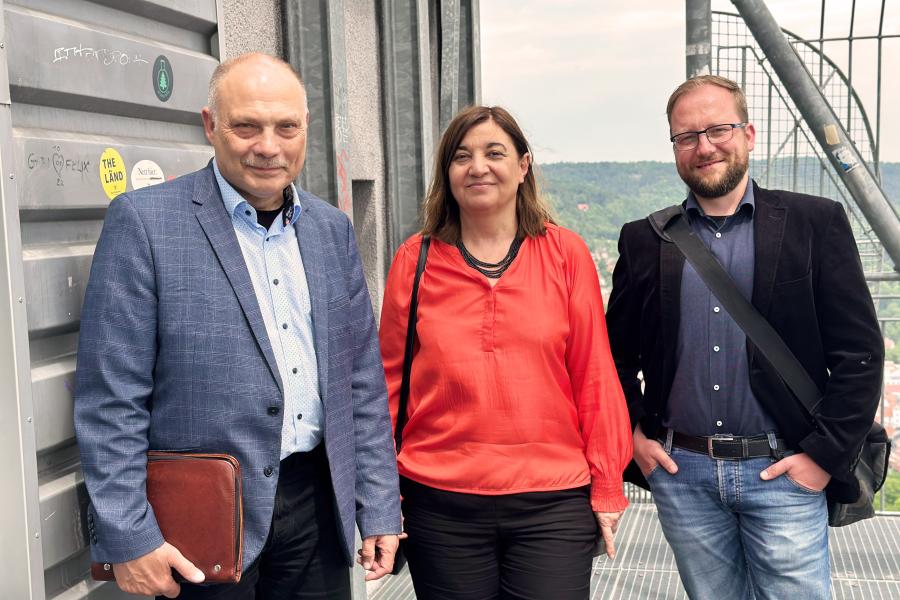 Eine Frau und zwei Männer schauen in die Kamera